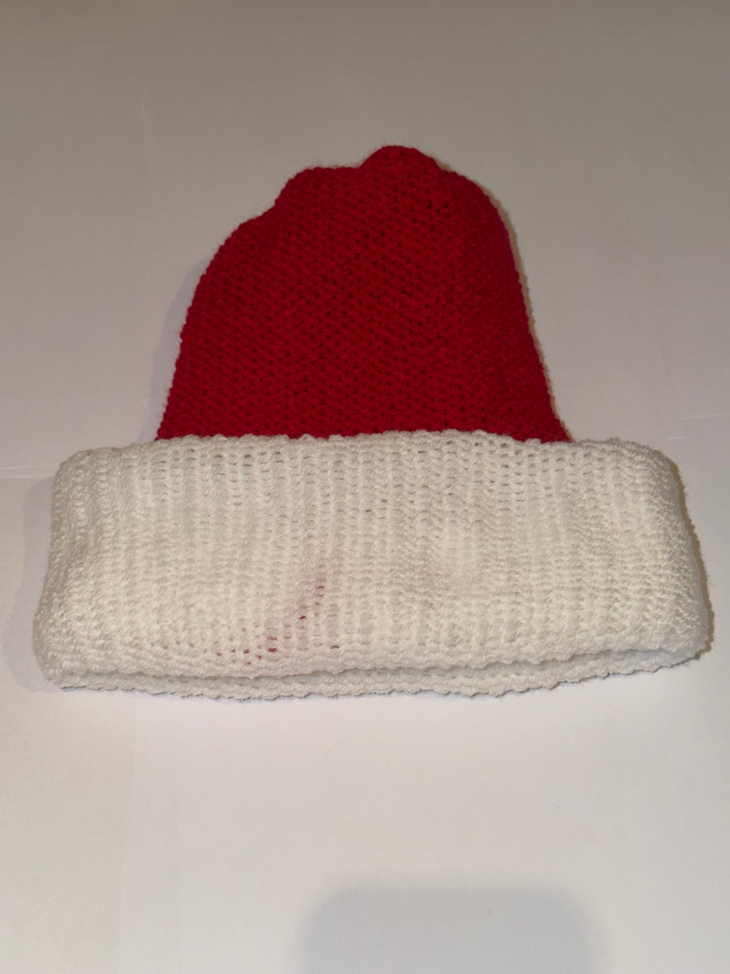Red and White Christmas Beanie displayed flat, showcasing the vibrant red crown and white cuff.