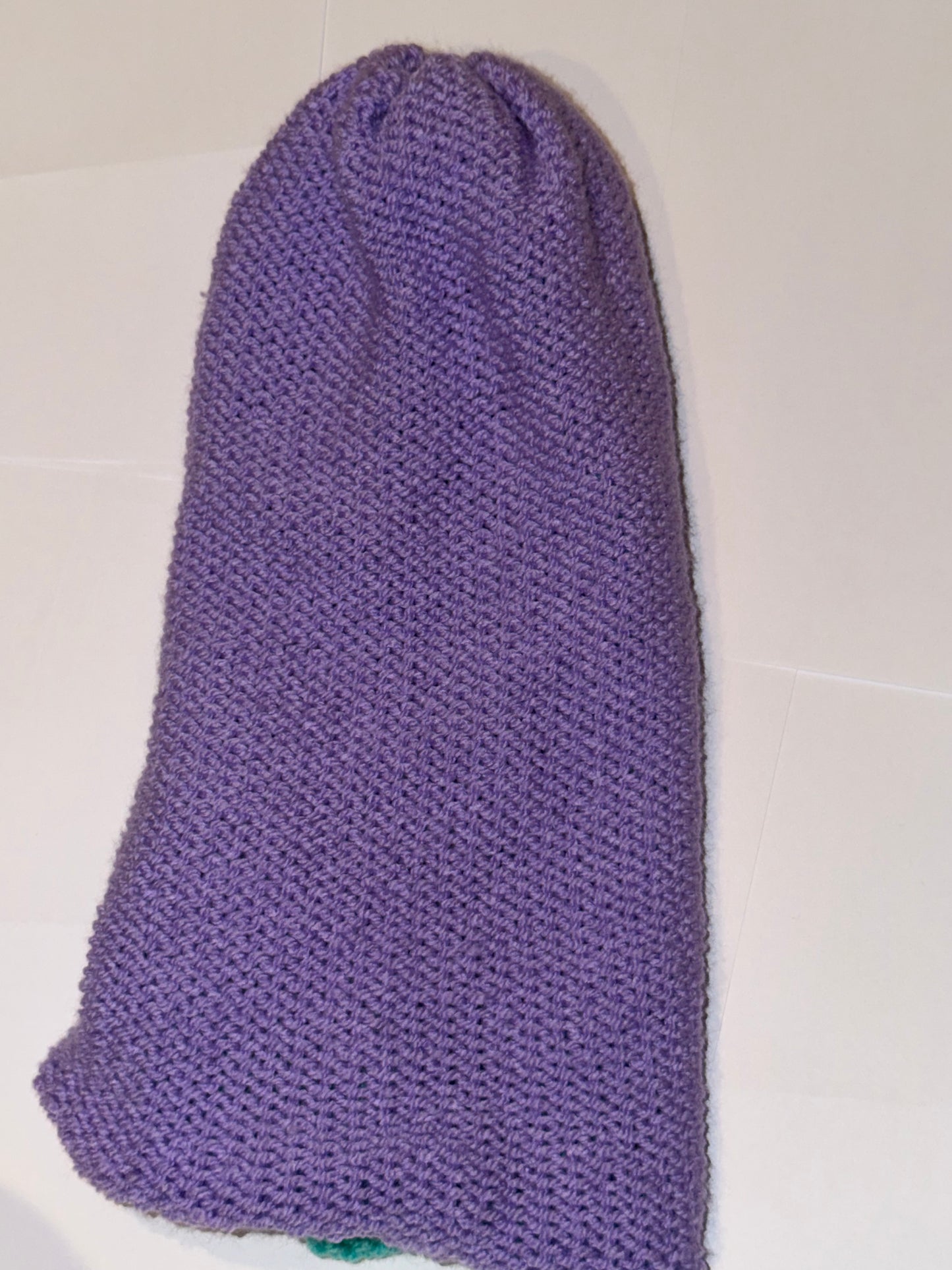 Handmade Reversible Wooly Beanie Bright Lilac and Aqua displayed in vibrant purple fabric.