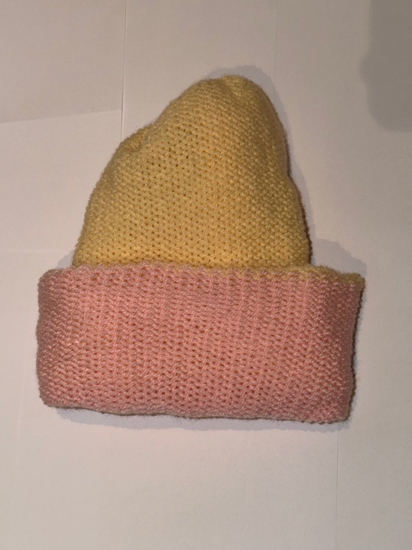 Handmade Reversible Wooly Beanie Light Pink and Cream displayed on a flat surface.