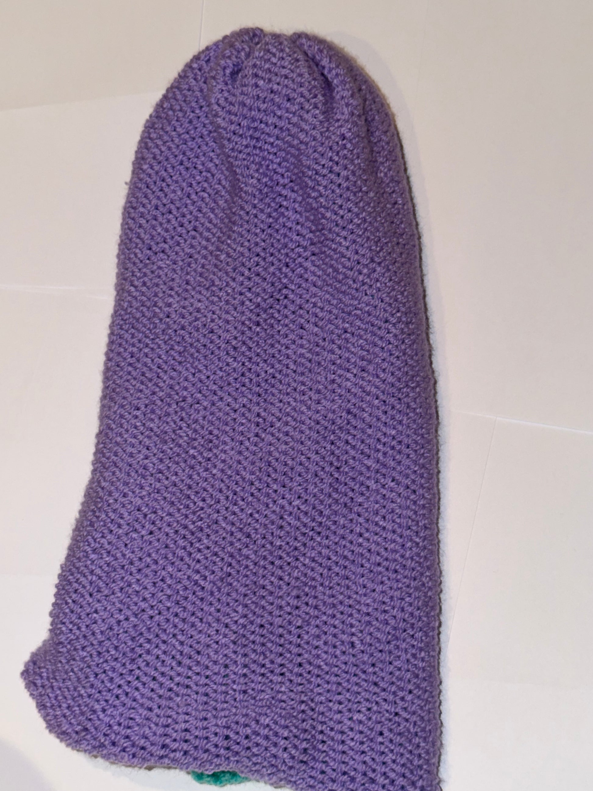 Handmade Reversible Wooly Beanie Bright Lilac and Aqua displayed in vibrant purple fabric.
